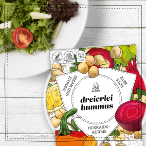 AlDar Mazza Dreierlei Hummus. Eine Verpackung auf einem gedeckten Tisch mit Salat.